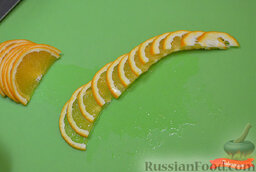 Роза из апельсина: Порезать апельсин вдоль волокон пополам. Порезать на тонкие слайсы около 2 мм.  Половину слайсов выложить в линию.