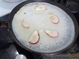 Блины с яблоками: Половником налейте блинное тесто на сковороду, при этом на огонь ее сразу не отправляйте, а выложите дольки яблок. И только после этого поставьте жариться блин.