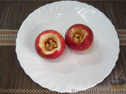 Яблочный десерт: Равномерно разложите арахис в каждое яблоко.