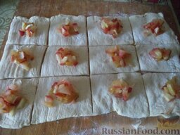 Яблочные слойки: Включить духовку. Разрезать тесто на квадратики. Выложить на каждый кусочек яблочную начинку (1-2 ч. ложки).