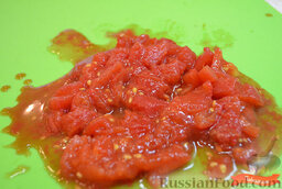 Томатный суп с лапшой: В кастрюле вскипятить воду.   Если томаты в банке неочищенные, снять с них кожуру. Нарезать мякоть помидоров кусочками.