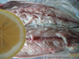 Скумбрия в фольге: Половину подготовленной рыбы уложить кожей вниз на лист фольги для кулинарных целей.  Сбрызнуть рыбу лимонным соком, посолить.
