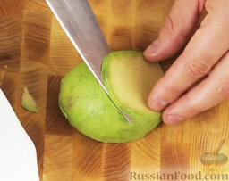 Салат с авокадо и вялеными томатами: Нарезаем авокадо под углом тонкими слайсами.  Авокадо выкладываем на сервировочную тарелку.