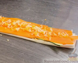 "Роллы" из цуккини с морковью: Выложить слайсы моркови в один слой. Посыпать сыром.