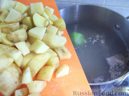 Зеленый борщ со щавелем и рисом: Тем временем очистите картофель, помойте и порежьте кубиками. После того, как вода с мясом закипит, добавьте в кастрюлю картофель и продолжайте варить все вместе.