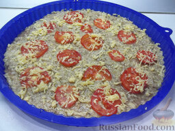 Пицца с помидорами из кабачкового теста: Помидоры помойте, порежьте кольцами и выложите их на овощное тесто. Твердый сыр натрите на крупной терке и присыпьте помидоры.