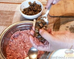Мясные зразы с грибами: Взять небольшую порцию фарша. Выложить сверху немного грибов. Чуть придавить.