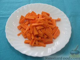 Жаркое из свинины: Морковь очистите, помойте, порежьте крупной соломкой и отправьте жариться к мясу. Готовьте мясо с морковью до золотистого цвета.