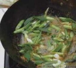 Рис с овощами: 2. В воке или другой большой сковороде разогреть растительное масло, выложить пасту карри, готовить около 1 минуты. Добавить зеленый лук и чеснок, жарить еще примерно 1 минуту.