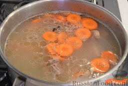 Зеленый борщ с говяжьими ребрами и перепелиными яйцами: Когда бульон сварится, добавляем нарезанный кубиком картофель и промытый рис, варим 20 минут.  Нарезаем очищенную морковь кружочками и отправляем в кастрюлю, варим около 5-10 минут, морковь должна быть немного хрустящей.
