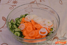 Маринованный салат: Нарезать морковь тонкими кружочками.  Нарезать лук тонкими колечками.  Высыпать морковь и лук в миску с огурцами.