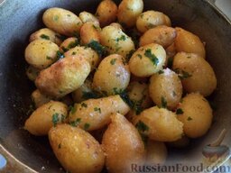 Жареная молодая картошечка: Посолить картофель по вкусу, добавить по желанию мелко нарезанный укроп или петрушку, аккуратно перемешать (перетряхнуть с закрытой крышкой) картофель.