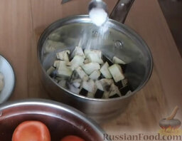 Салат из перца на зиму: Посыпать нарезанный баклажан солью, перемешать и оставить примерно на 10 минут.