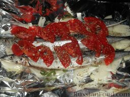 Сайра, запеченная с помидорами: Посыпать рыбу пряными травами.  Закрыть рыбу фольгой, запекать в духовке 30-40 минут при температуре 190 градусов.