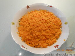 Салат "Солнечный тунец": Натереть на терке морковь и выложить её на салат. 