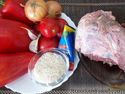 Фаршированный перец, тушенный в духовке: Необходимые ингредиенты для приготовления фаршированного перца в духовке: болгарские перцы, свинина на кости, рис, репчатый лук, помидоры, томатная паст, чеснок.