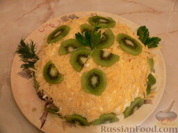 Салат "Хелел": Готовый салат украсить киви и зеленью, отправить в холодильник на несколько часов.  Салат готов. Приятного аппетита!
