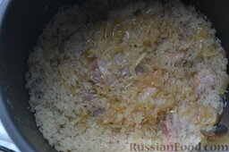 Курица со специями, приготовленная с рисом в мультиварке: Сверху курицы выкладываю промытый рис, обжаренный лук, солю. Вставляю в рис неочищенную головку чеснока. Если для этого рецепта использую рис басмати, то его заранее замачиваю водой. Пропаренный же рис замачивать не обязательно, достаточно его лишь промыть.