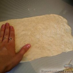 Итальянские хлебные палочки "Гриссини": Тесто разделить на несколько частей (обычно получается три кусочка). Раскатать каждый кусочек в прямоугольник (у меня по размерам получается 10-15 см на 25-30 см) толщиной 2-5 мм. Пласт посыпать кунжутом и/или тертым сыром, немного вдавить их в тесто.