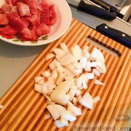 Свинина в соусе на основе японского блюда "Оякодон": Мясо нарезать кубиками.  Лук нашинковать. В сковороде разогреть растительное масло.