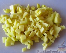 Картофельный суп с вешенками и плавленым сырком: Почистить и порезать мелкими кубиками 2 картофелины.   Высыпать картофель в кипящий бульон, варить на небольшом огне почти до полного разваривания, примерно 15-20 минут.
