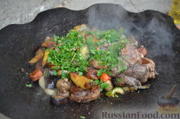 Мясо с овощами и яичницей на природе: Посыпаем блюдо рубленой петрушкой.