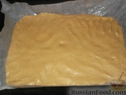 Песочное пирожное с глазурью: Включить духовку. Противень застелить пергаментом, смазать маслом. Выложить тесто на противень, разровнять в прямоугольный пласт толщиной 1,5 см.  Выпекать при температуре 180 градусов 15-20 минут.
