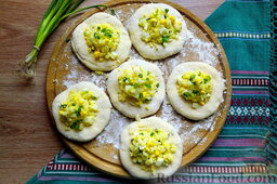 Пирожки с рисом, яйцом и зелёным луком: По центру кружков из теста поместите горки начинки.