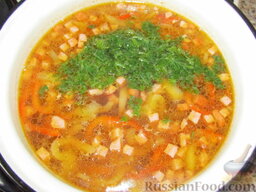 Фасолевый суп с болгарским перцем: Через пять минут добавьте колбасу в суп. Присолите по вкусу. Положите специи. Нарежьте зелень и также добавьте в суп. Проварите еще 5-10 минут и отставляйте.