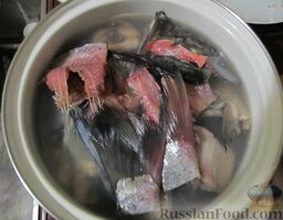 Уха наваристая с рисом: Всю рыбу сложить в большую кастрюлю, залить водой, чтобы она примерно на 1 см не покрывала верхний слой. У меня ушло 2 литра. Довести до кипения.