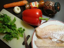 Рыба по-мароккански: Рыбное филе вымыть, обсушить, при необходимости порезать на порционные куски.   Очистить и нарезать овощи: перец - полосками, чеснок и морковь - ломтиками, измельчить петрушку.  Разогреть духовку до 180 градусов.