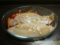 Рыба по-мароккански: Затем выложить половину чеснока (и порезанную кинзу, если есть; в Италии ее нет, мне не судьба). Затем рыбу. Посолить, посыпать оставшимся чесноком.