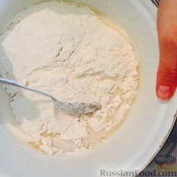 Домашний хлеб на молоке: Постепенно добавить муку и замесить тесто.