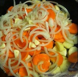 Куриные ножки и гарнир: Картофель и морковку чистим, моем и нарезаем.  Лук режем полукольцами, чеснок - кругляшками.   Все это выкладываем в форму для запекания.