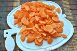 Хек в томате: Морковку очищаем и нарезаем пластинами, которые можно разделить дополнительно на две или четыре части при необходимости.