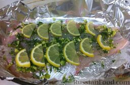 Судак, запеченный в духовке, с имбирем, чесноком и перцем чили: Выложить лимон на рыбу.  Поместить рыбу в духовку, разогретую до 200 градусов, готовить 30 минут.