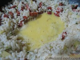 Рис с жареной колбасой и яйцами: В центре сделать лунку и влить в нее взбитые яйца.
