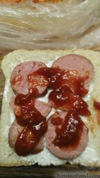 Сэндвич "Завтрак для мужа": На ломтик хлеба выложить 4 кружочка нарезанной сардельки, смазать кетчупом.