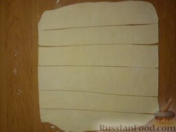Съедобные "розы": Размораживаем слоеное тесто. Раскатываем тесто в пласт толщиной 3 мм. Нарезаем тесто полосами шириной 2 см и длиной 25-30 см.