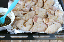 Глазированные куриные крылышки по-азиатски: Наносим кисточкой глазурь с кусочками имбиря и чеснока на каждое крылышко. Ставим в духовку и устанавливаем таймер на 7-10 минут.