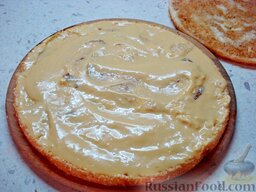 Бисквитный торт с безе «Воздушный»: Отложить третью часть масляного крема для украшения торта.  Нанести слой крема на корж.