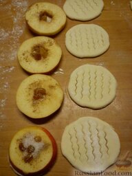 Яблочные тарталетки с изюмом: Яблоки посыпаем ванилью, корицей, выкладываем в лунку.
