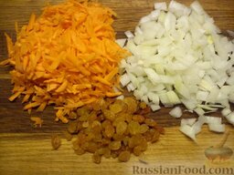Плов с мандаринами и изюмом: Трем морковь на средней терке, шинкуем лук и высыпаем горсть изюма.