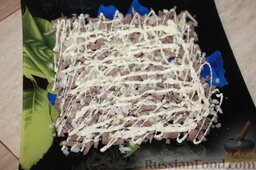 Слоеный салат из свиного языка: Выложить нарезанным мясом первый салатный слой. Сверху к языку добавьте маринованный лук, он уже будет готов. Затем смажьте майонезом.