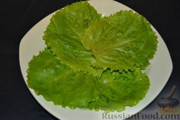 Салат с кальмарами и огурцами: В салатницу выкладываем вымытые четыре листочка салата.
