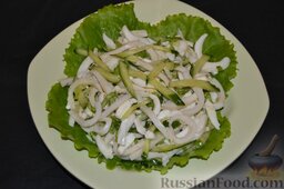 Салат с кальмарами и огурцами: На зелень выкладываем салат из кальмаров.