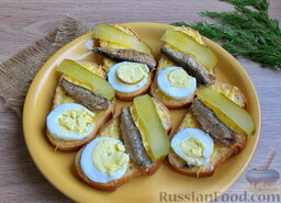 Бутерброды со шпротами: Далее уложить кружочки яйца и ломтики огурца.