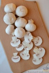 Салат из кальмаров с грибами: Шампиньоны вымываем, очищаем, нарезаем вдоль гриба дольками. Можно оставить так, а можно эти дольки ещё пополам разрезать. Это будет зависеть от размеров грибов.