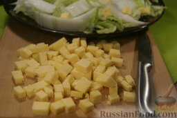 Салат с тунцом: Измельчите сыр небольшими кубиками. Густо посыпьте им воздушный слой капусты.