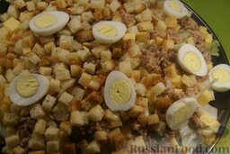 Салат с тунцом: Предварительно сварите перепелиные яйца. Почистите их и аккуратно разрежьте на две части. Разложите половинки симметрично по всей поверхности салата.